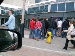 fans lined up outside large arena ticket wicket