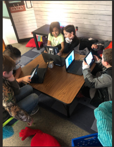 young students gather around table while using smartphones and app