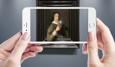 hands hold smartphone with art gallery app on screen