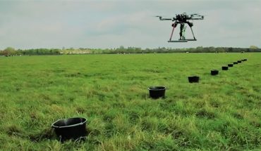 drones hover over open field above row of targets
