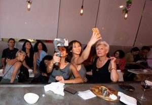 women taking selfies in bar setting