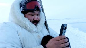 Inuit man using smartphone app outdoors