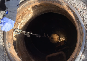 sensor unit being lowered into manhole