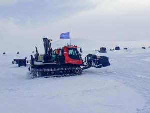 snow tractor on treads climbs snow mound