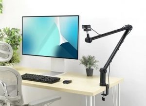 webcam mounted on boom arm near Mac computer