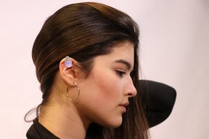 woman has small digital device on ear