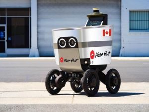 A food delivery robot on wheels, with Pizza Hut and Canadian flag emblazoned on device.