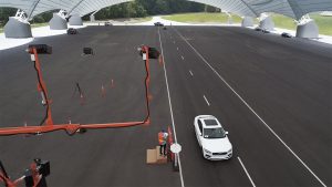 technicians using cameras monitor a roadway with automobiles