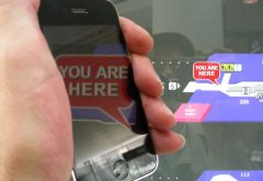 hand holds smartphone, screen show words You Are Here