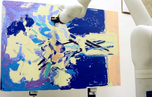 robotic arm applies paint to canvas in this freeze frame