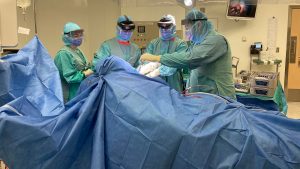 health care staff wearing mixed reality headsets prepare for surgery in operating room