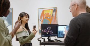 people wearing headsets gather in art gallery