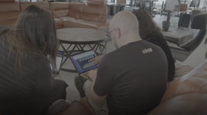 people seated at table looking at computer screen