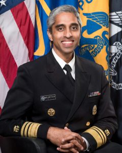 man in uniform in front of U.S. flags