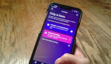 hand holding smartphone with mental health app on screen