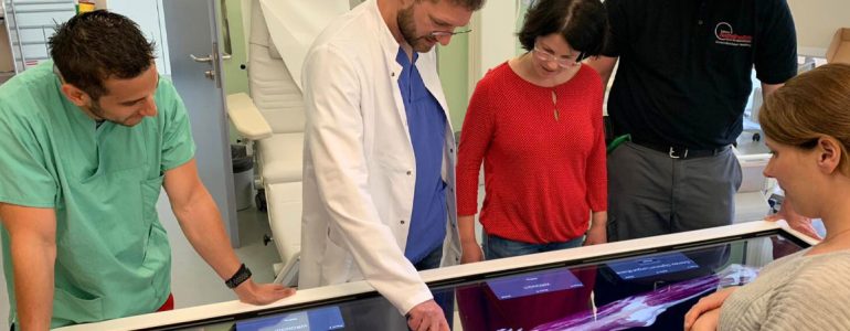 students and faculty gather around Anatomage Table