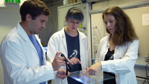 people in lab coats look at treated glass material