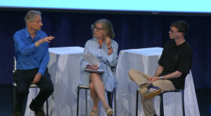 three people seated on stools on a stage; Hinton at left, Frosst at right, Young in the middle
