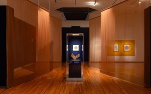 entry space in museum setting shows printed artworks on display