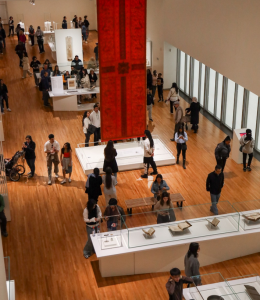 several visitors browse large exhibition space in museum