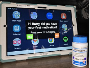 seniors tablet with reminder on screen and medicine bottle alongside