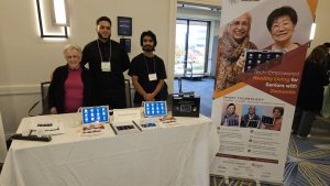 staff at a table show smart tablets during a senior conference