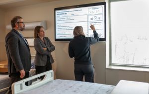 hospital staff looks at info on large digital screen