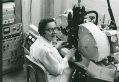 photo of woman in lab coat seated in laboratory