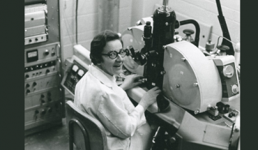 photo of woman in lab coat seated in laboratory