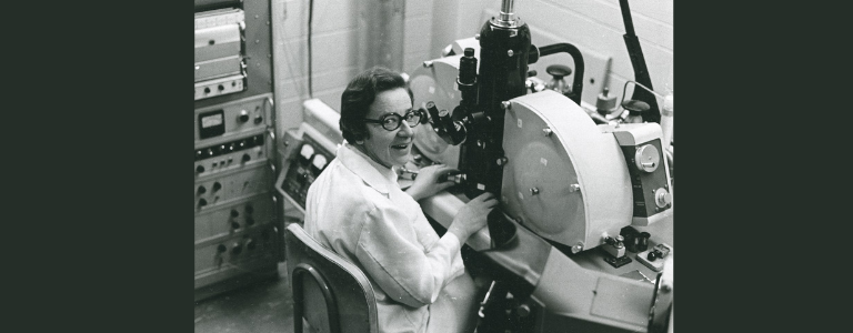 photo of woman in lab coat seated in laboratory