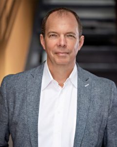 man in open jacket looks to camera