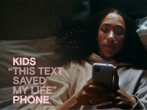 young female looks at smartphone