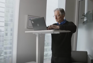 man types at computer on standing desk