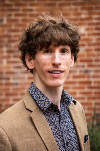 man in sports jacket looks at camera