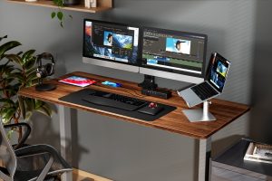 computer desk with monitors, laptop, tablets, headphones and docking station
