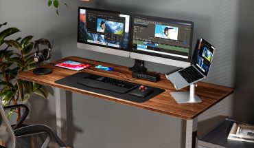 computer desk with monitors, laptop, tablets, headphones and docking station